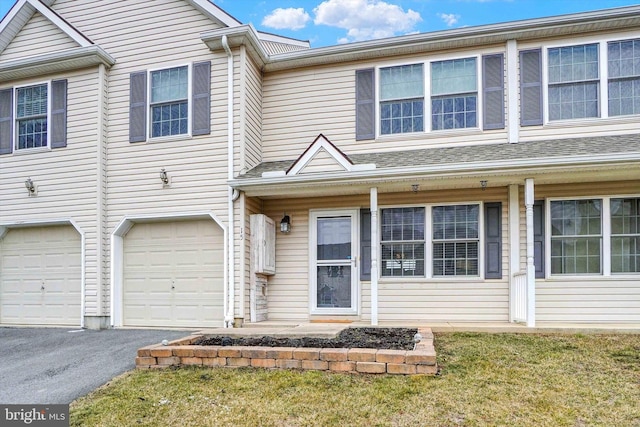 townhome / multi-family property with a garage and a front lawn