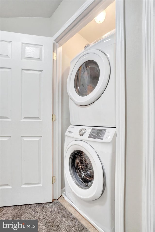 washroom with stacked washing maching and dryer