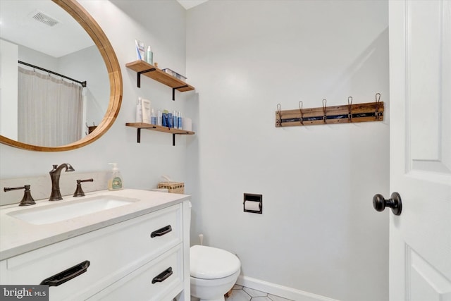 bathroom featuring tile patterned floors, vanity, and toilet