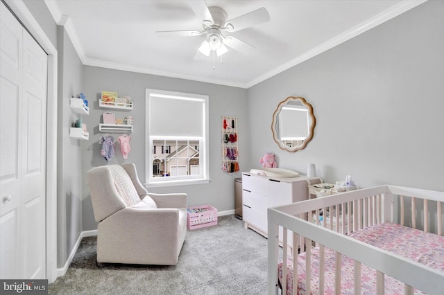 bedroom with crown molding, carpet floors, a closet, ceiling fan, and a crib