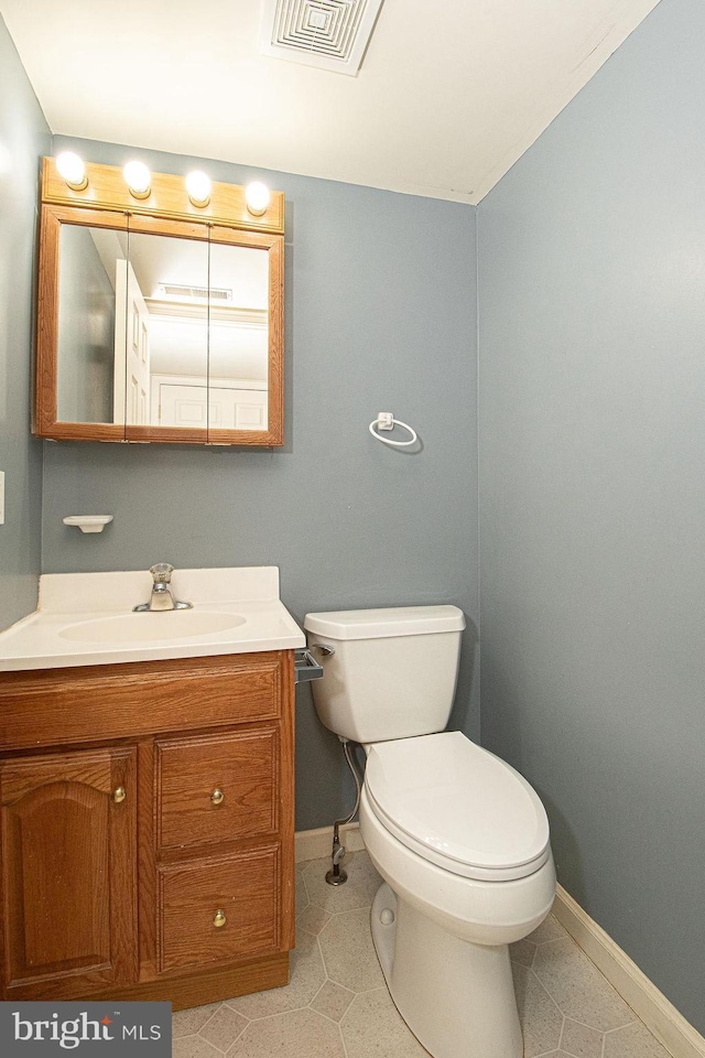 bathroom with visible vents, toilet, vanity, tile patterned flooring, and baseboards