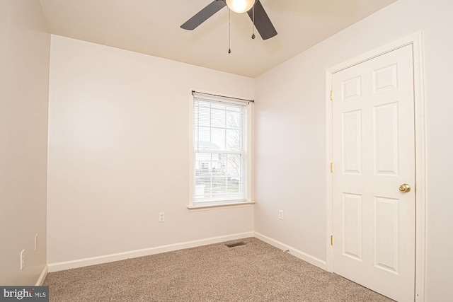 empty room featuring ceiling fan, carpet floors, visible vents, and baseboards