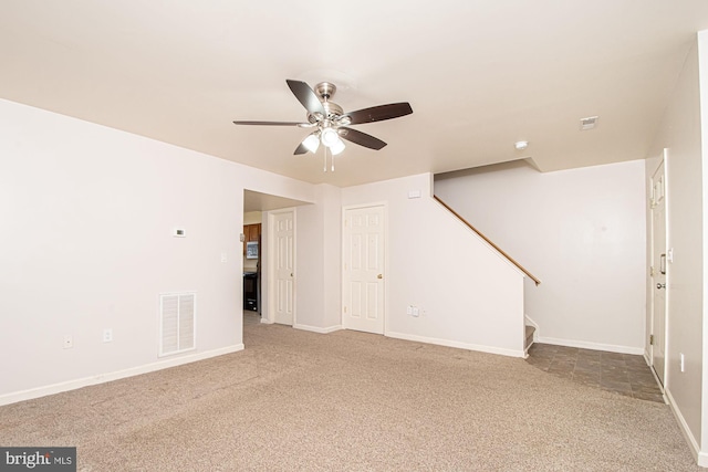 unfurnished room featuring visible vents, stairway, carpet flooring, ceiling fan, and baseboards