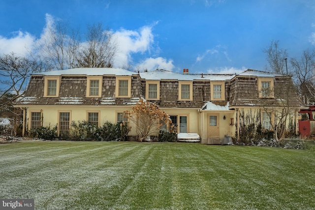 rear view of house featuring a lawn