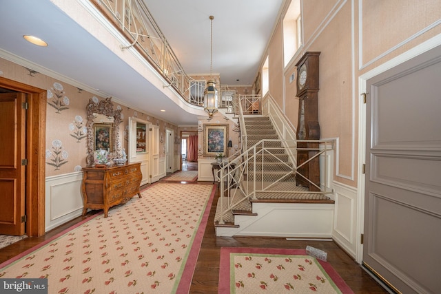 entryway featuring ornamental molding, hardwood / wood-style floors, and an inviting chandelier