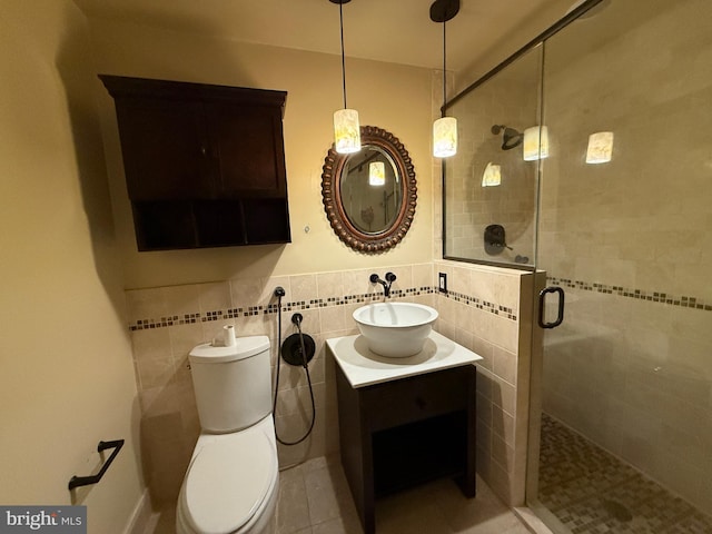 bathroom featuring toilet, tile walls, vanity, and walk in shower