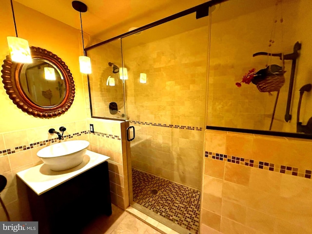 bathroom featuring a shower with door, vanity, and tasteful backsplash