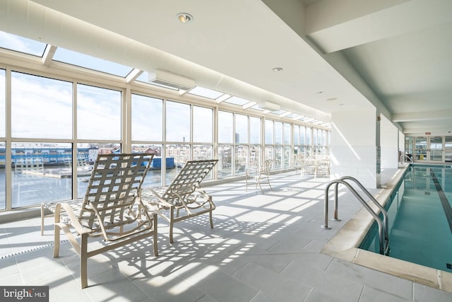 view of swimming pool featuring a skylight and a wall mounted AC