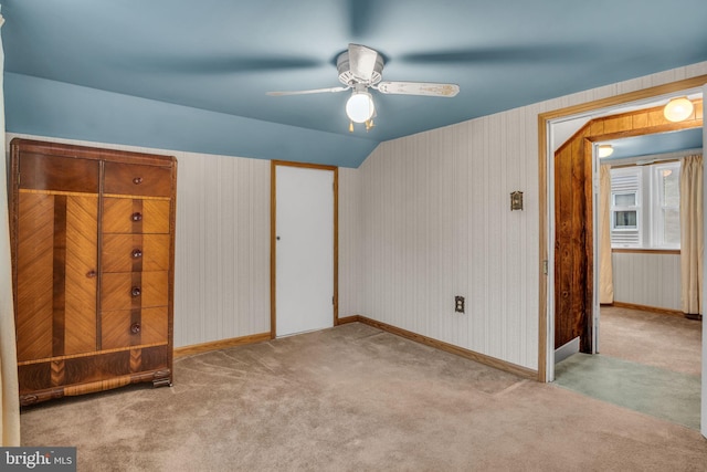 unfurnished bedroom featuring ceiling fan, light colored carpet, and vaulted ceiling