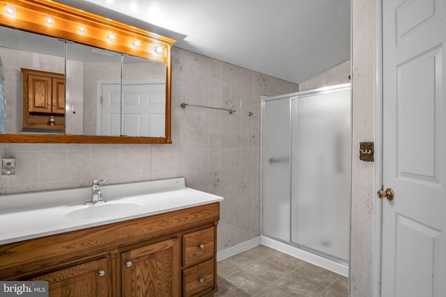 bathroom featuring vanity, tile walls, and a shower with shower door