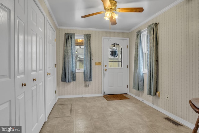 tiled entryway featuring crown molding and ceiling fan