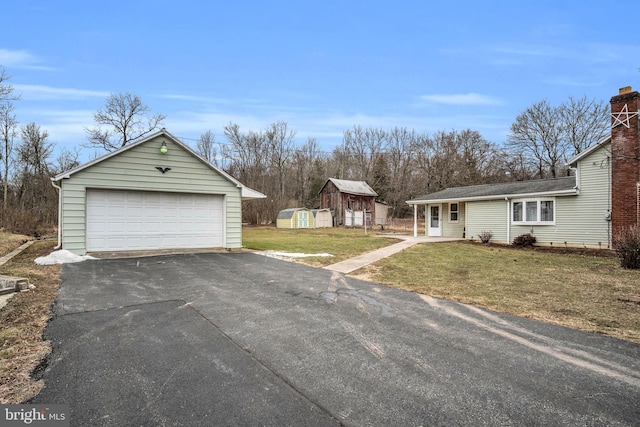 exterior space featuring a storage unit, a front yard, and a garage