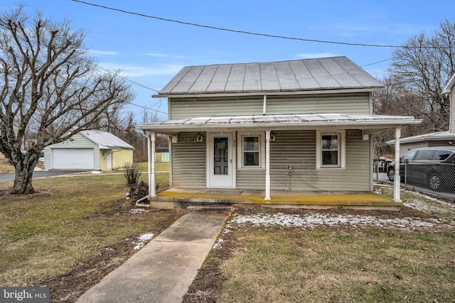 view of front of home with an outbuilding, a porch, a garage, and a front lawn