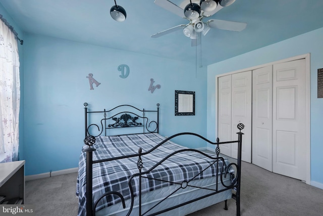 carpeted bedroom featuring ceiling fan and a closet