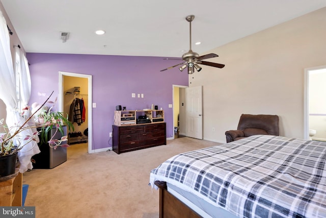 bedroom with ensuite bath, a spacious closet, light colored carpet, a closet, and ceiling fan