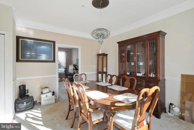 carpeted dining area featuring ornamental molding