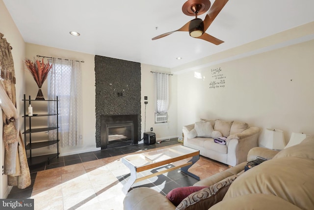 tiled living room with ceiling fan and a large fireplace