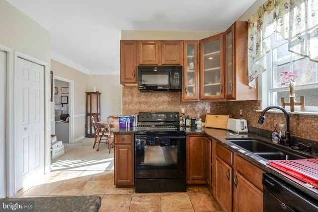 kitchen with sink, dark stone countertops, ornamental molding, decorative backsplash, and black appliances