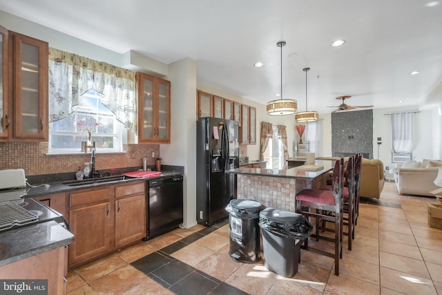 kitchen with pendant lighting, sink, backsplash, and black appliances