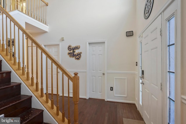 entryway featuring a towering ceiling and dark hardwood / wood-style floors