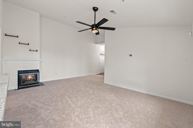 unfurnished living room with high vaulted ceiling, light colored carpet, and ceiling fan