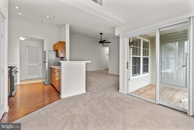 kitchen with ceiling fan, light colored carpet, and appliances with stainless steel finishes