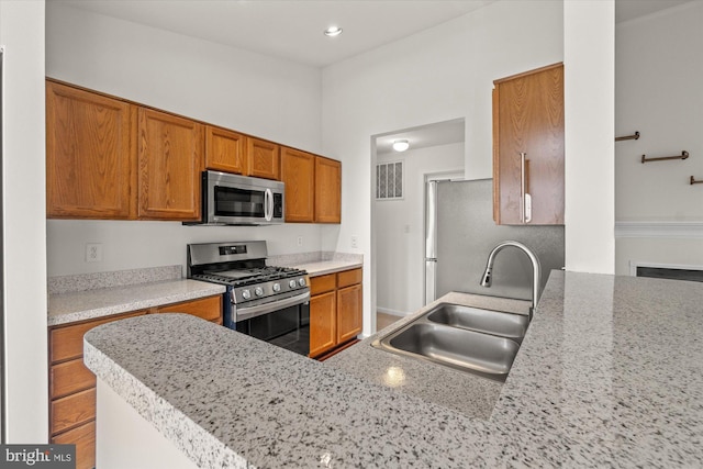 kitchen with stainless steel appliances, kitchen peninsula, and sink