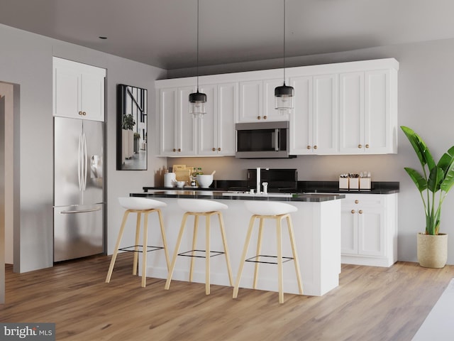 kitchen featuring stainless steel appliances, white cabinetry, hanging light fixtures, and a kitchen bar