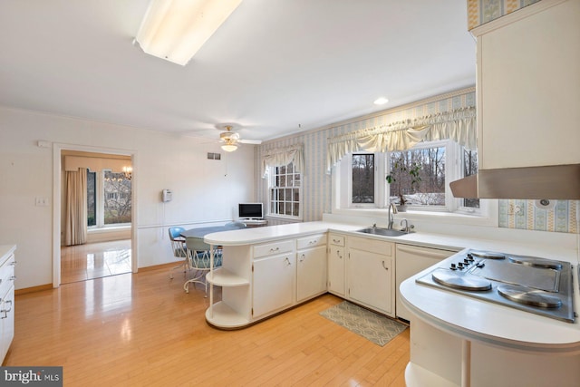 kitchen with sink, white cabinets, ceiling fan, kitchen peninsula, and light hardwood / wood-style flooring