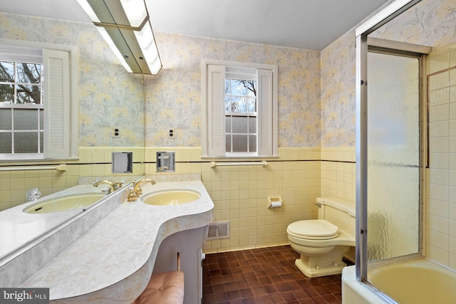 full bathroom with tile patterned floors, toilet, combined bath / shower with glass door, tile walls, and vanity