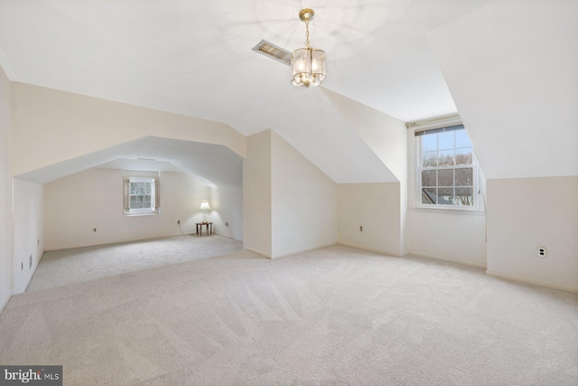 additional living space with light colored carpet, lofted ceiling, and a chandelier