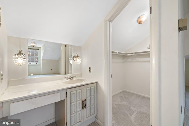 bathroom featuring vaulted ceiling and vanity