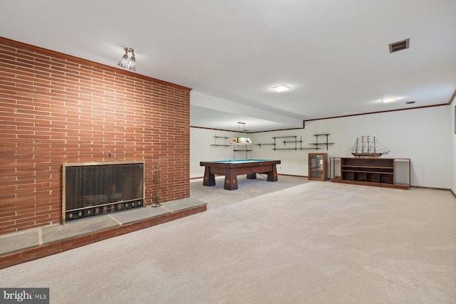 rec room featuring light carpet, a brick fireplace, crown molding, and pool table