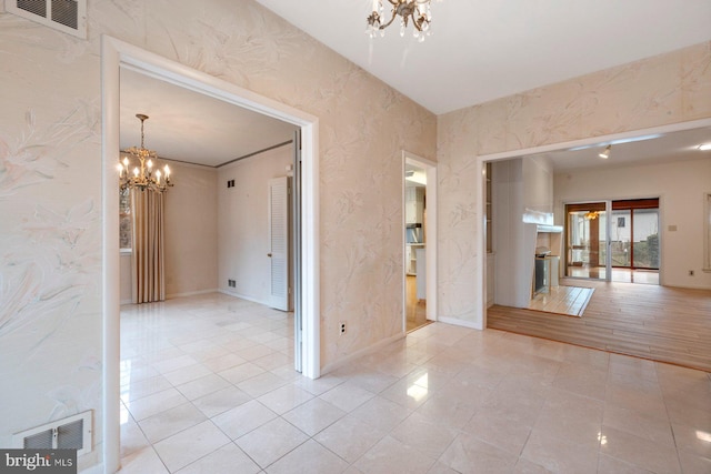 unfurnished room with a chandelier and light tile patterned flooring