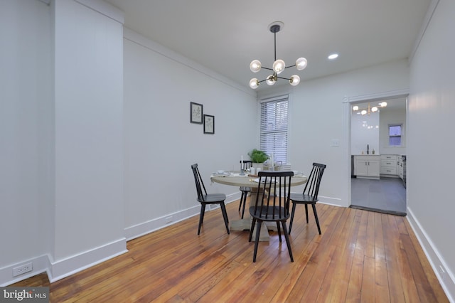 dining space featuring hardwood / wood-style flooring, sink, and a notable chandelier