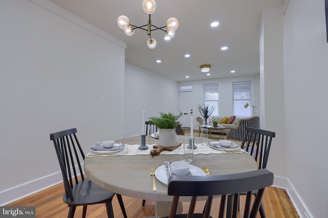 dining space featuring light hardwood / wood-style flooring and a notable chandelier