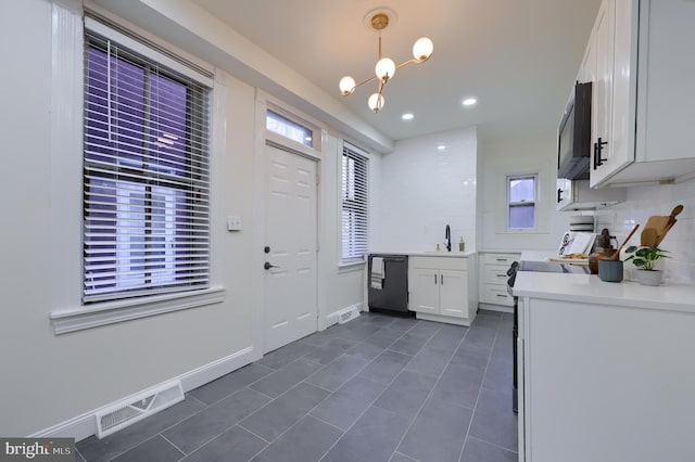 kitchen with sink, hanging light fixtures, tasteful backsplash, black appliances, and white cabinets