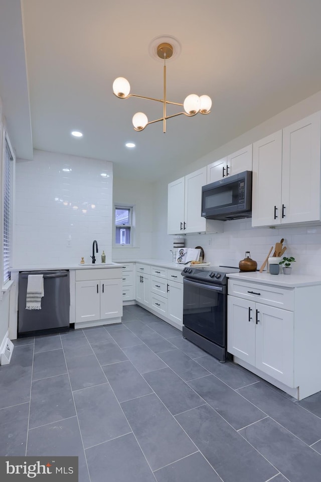 kitchen featuring range with electric cooktop, white cabinetry, dishwasher, hanging light fixtures, and dark tile patterned floors