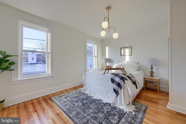 bedroom with hardwood / wood-style flooring and multiple windows