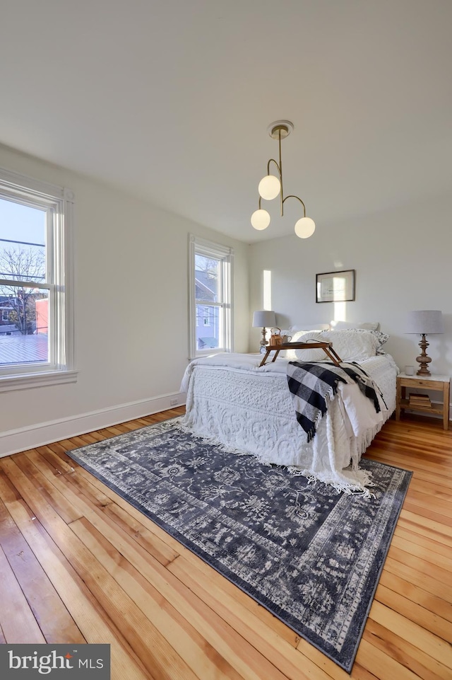 bedroom featuring an inviting chandelier and hardwood / wood-style floors