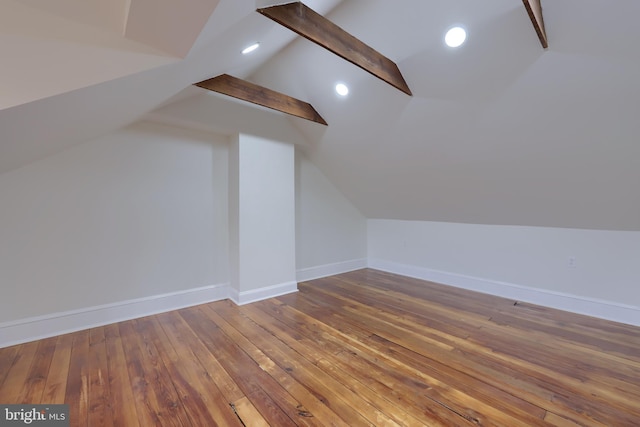 additional living space with lofted ceiling with beams and hardwood / wood-style floors