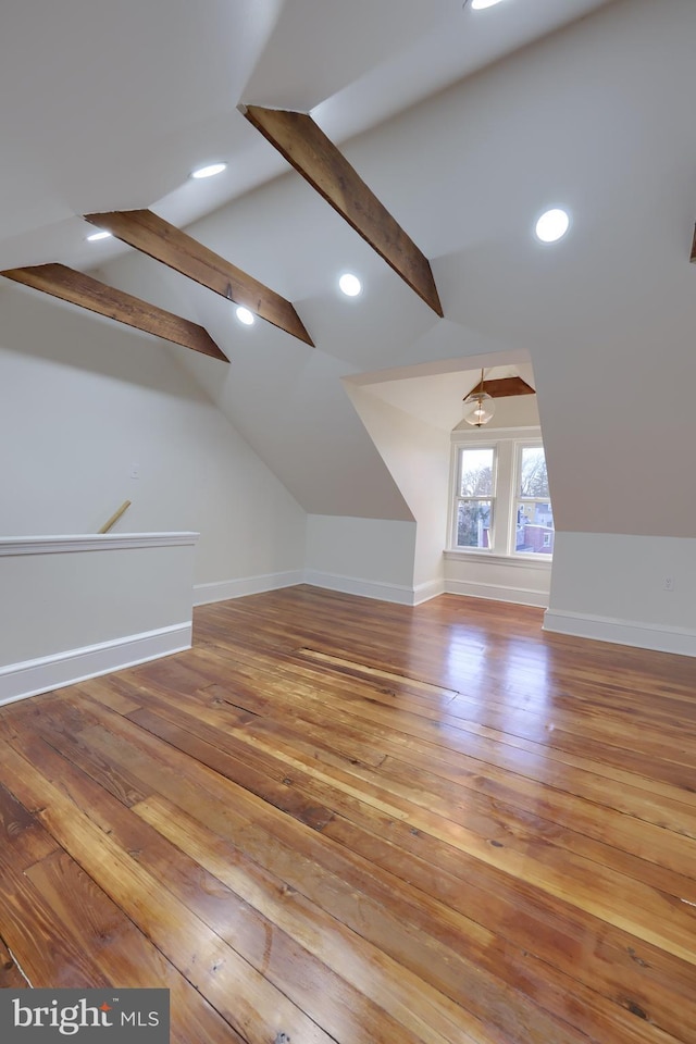 additional living space featuring lofted ceiling with beams and light wood-type flooring