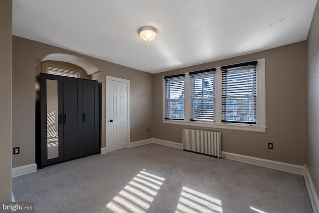 interior space featuring light colored carpet and radiator