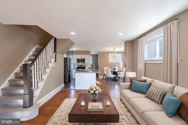 living room with sink, hardwood / wood-style flooring, and a chandelier