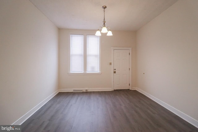 unfurnished dining area featuring dark wood-style flooring and baseboards