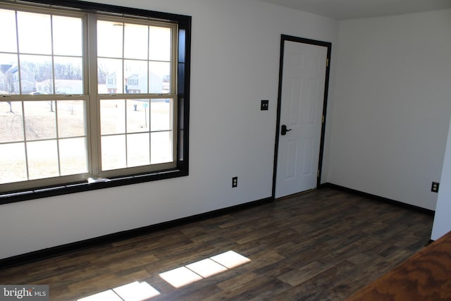 unfurnished room featuring dark wood-style floors and baseboards