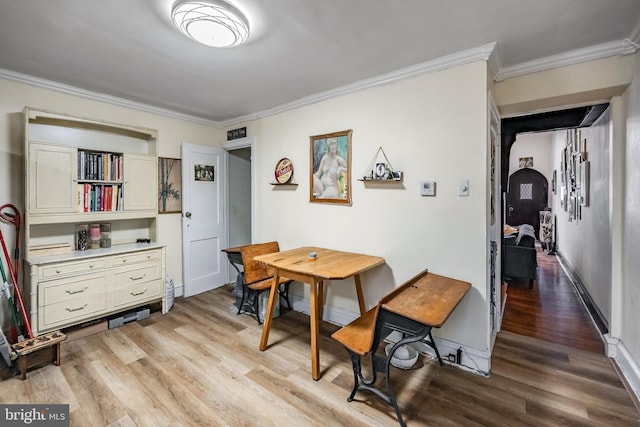 dining area featuring ornamental molding and light wood-type flooring