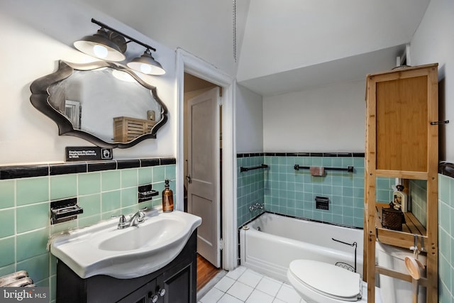 bathroom featuring tile walls, vanity, a tub to relax in, tile patterned floors, and toilet