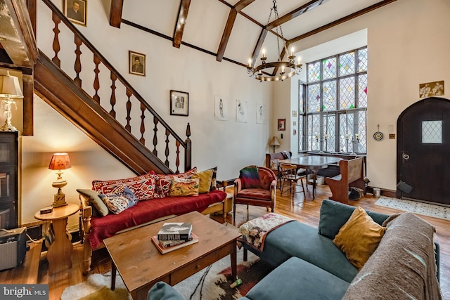 living room featuring beam ceiling, wood-type flooring, high vaulted ceiling, and a chandelier