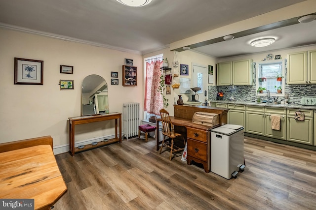 kitchen with hardwood / wood-style flooring, crown molding, radiator, and green cabinets